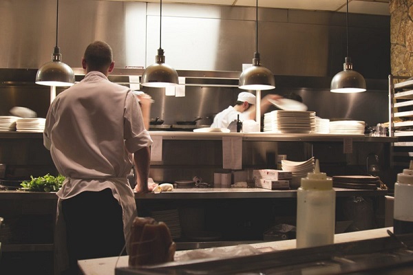 The Image Showing A Person Works In A Restaurant Kitchen And The Safety Standards Followed Is Shown.