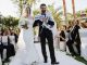 Picture Featuring Happy Sming Bride & Groom Entering To The Stage In Their Grand Wedding Ceremony In A Restaurant.