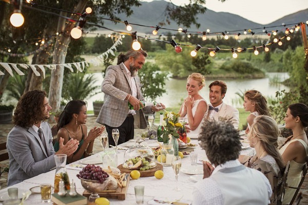 Image Featuring Wedding Guests Enjoying The Food With Bride & Groom In A Restaurant Wedding Reception.