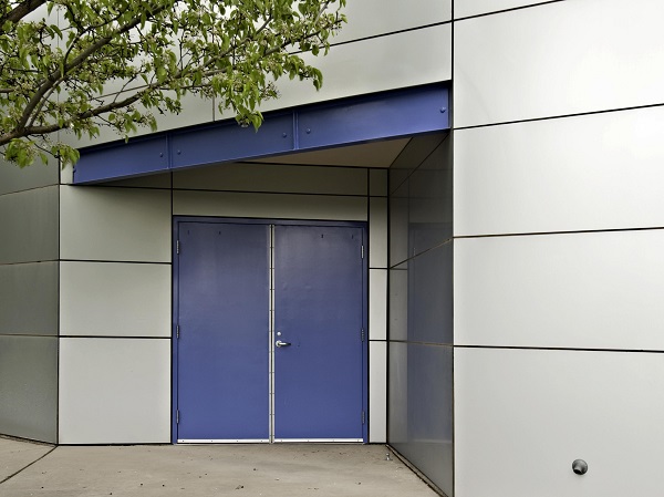 Exterior of a modern commercial unit with blue coloured steel door.