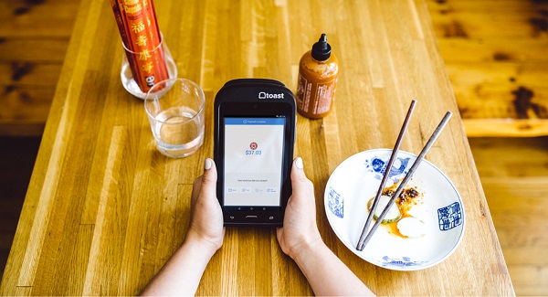 A customer at an restaurant is using his smartphone with the help of DAS wifi facility at the restaurant.