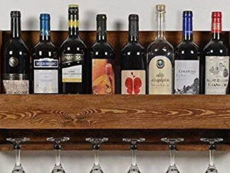 Wine bottles are arranged in a wooden rack with the wine glasses