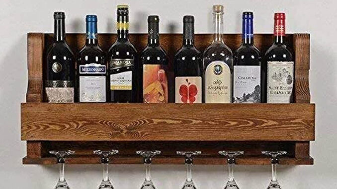 Wine bottles are arranged in a wooden rack with the wine glasses